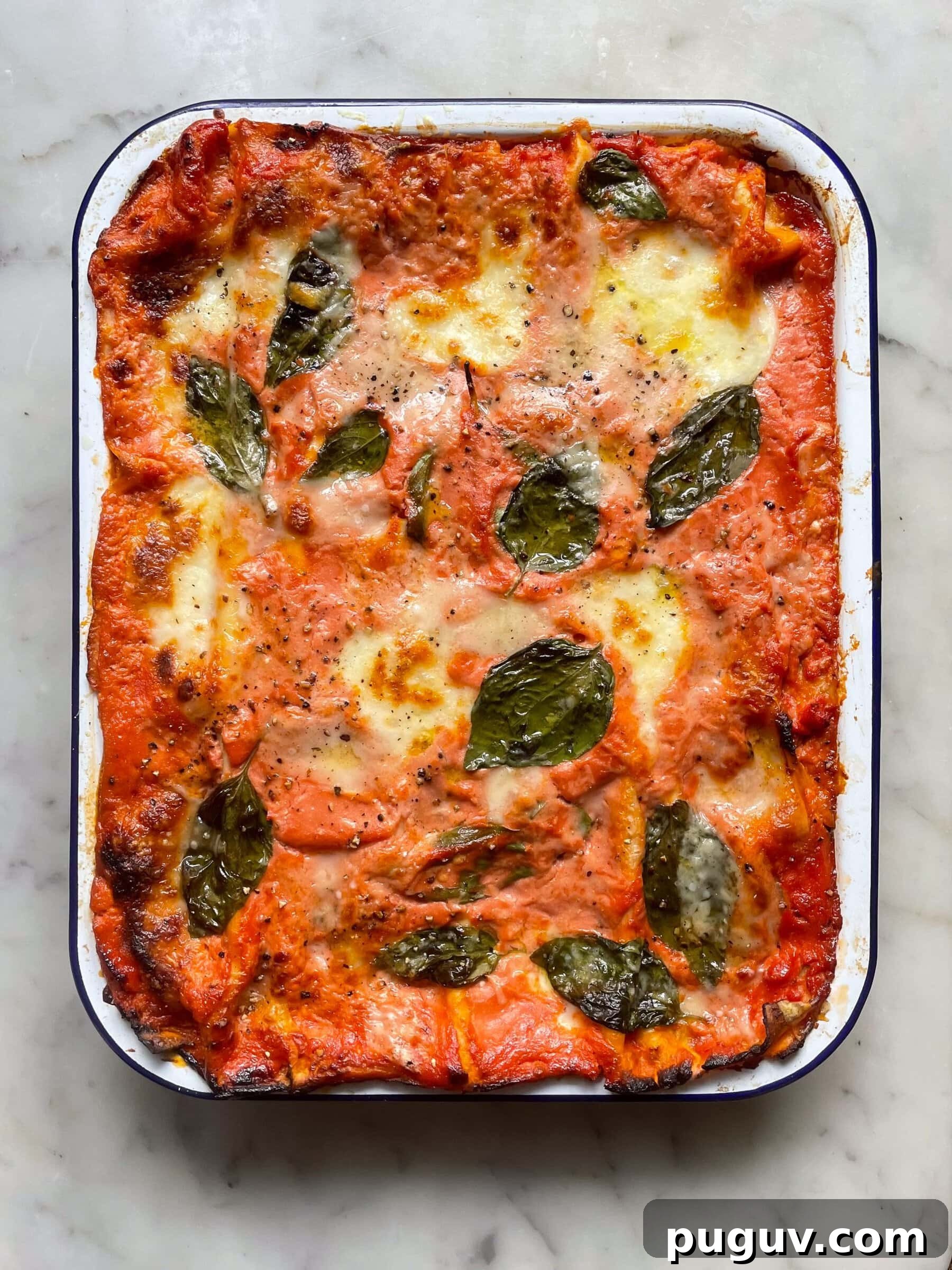 Bake courgette lasagne in a falconware baking dish topped with basil leaves.