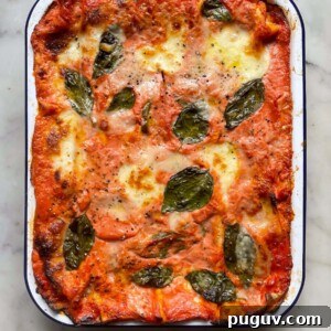Bake courgette lasagne in a falconware baking dish topped with basil leaves.