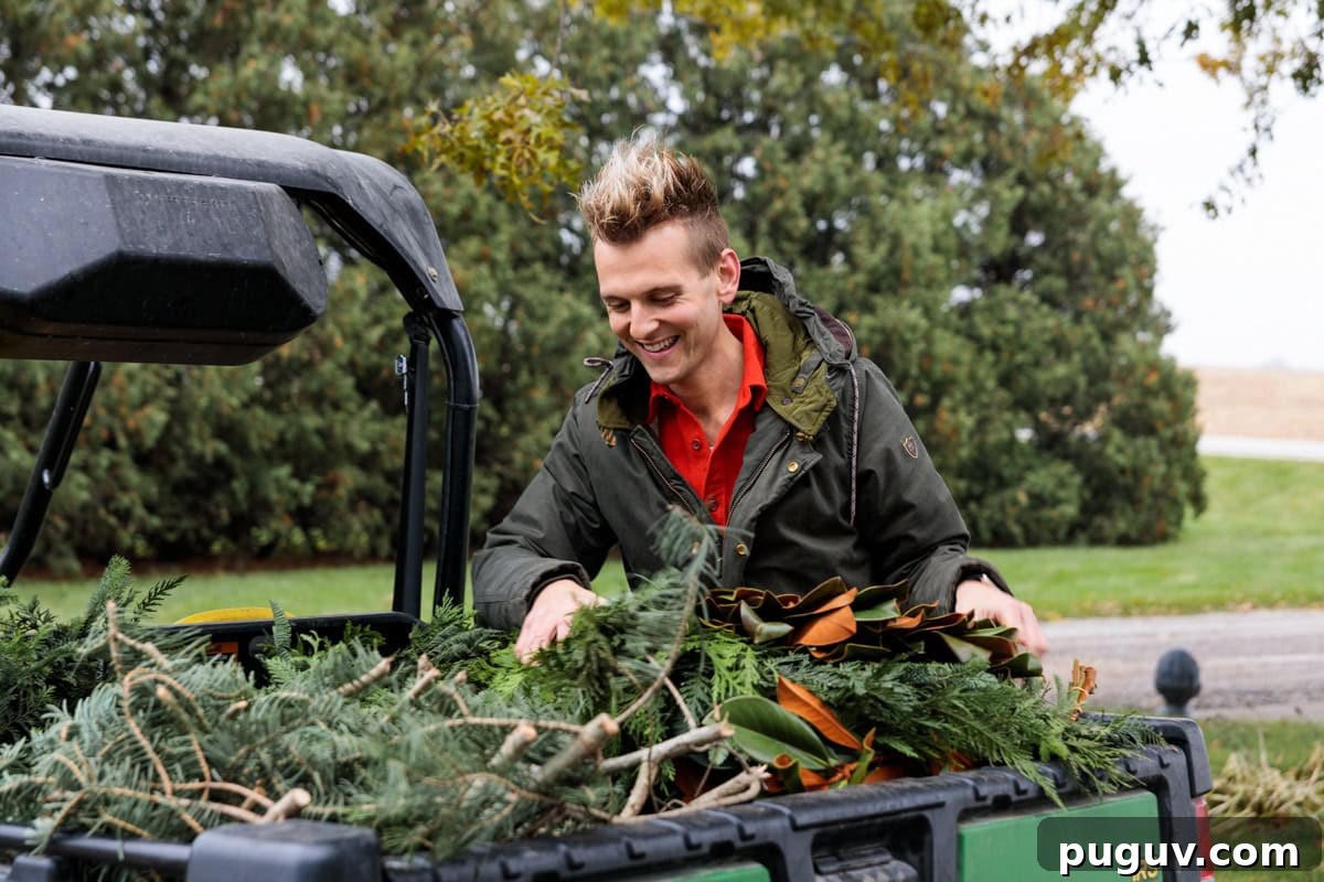 Kaleb Wyse wearing coat outdoors getting greens for outdoor Christmas decor from the back of a work vehicle.