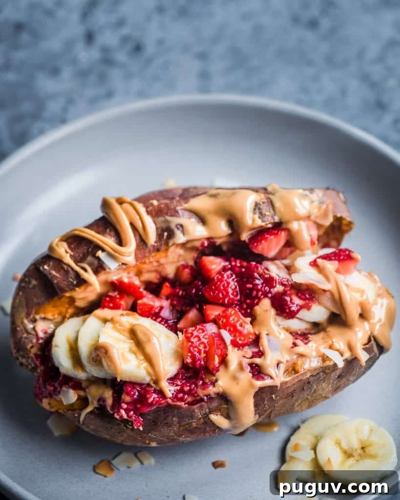 baked sweet potato stuffed with peanut butter, raspberry chia jam, bananas, and strawberries