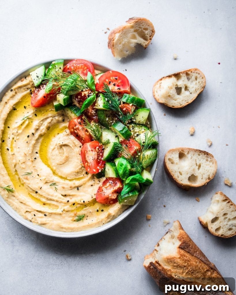 creamy hummus swirled with olive oil, topped with cucumbers and tomatoes