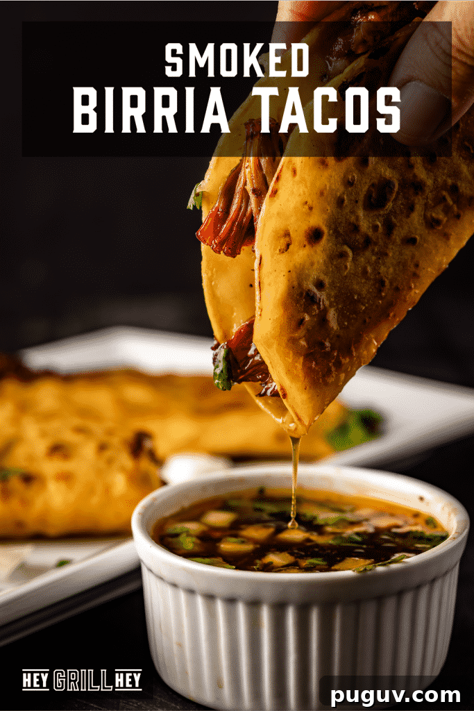 Smoked birria taco being dipped in consomme with text overlay - Smoked Birria Tacos.