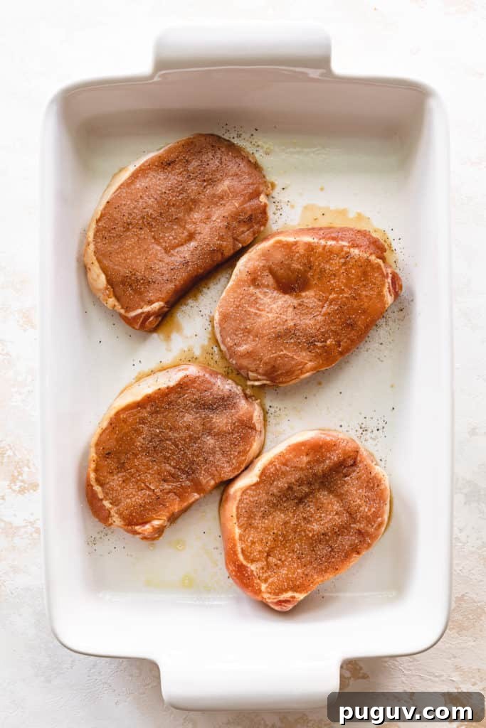 Marinated pork chops with salt and pepper in a baking dish.