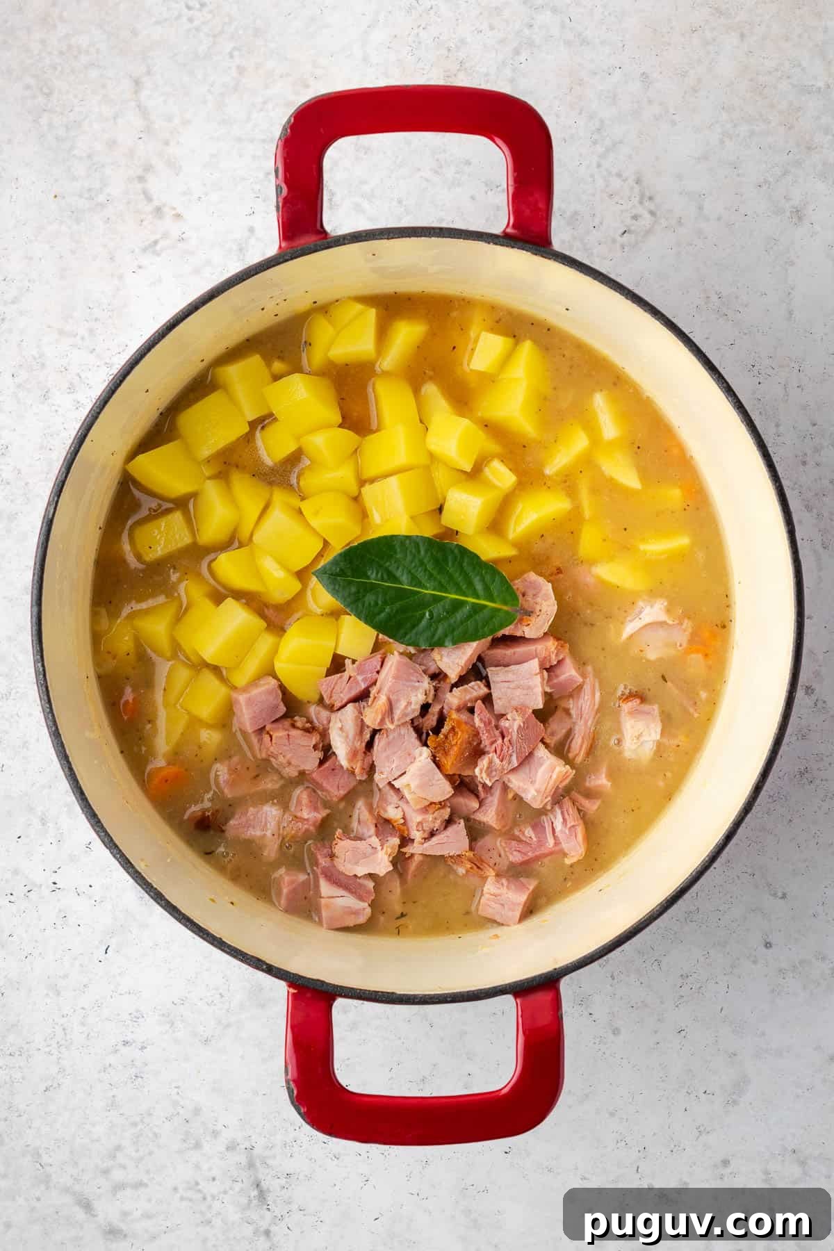 Potatoes and ham added into the soup pot with the remaining broth.