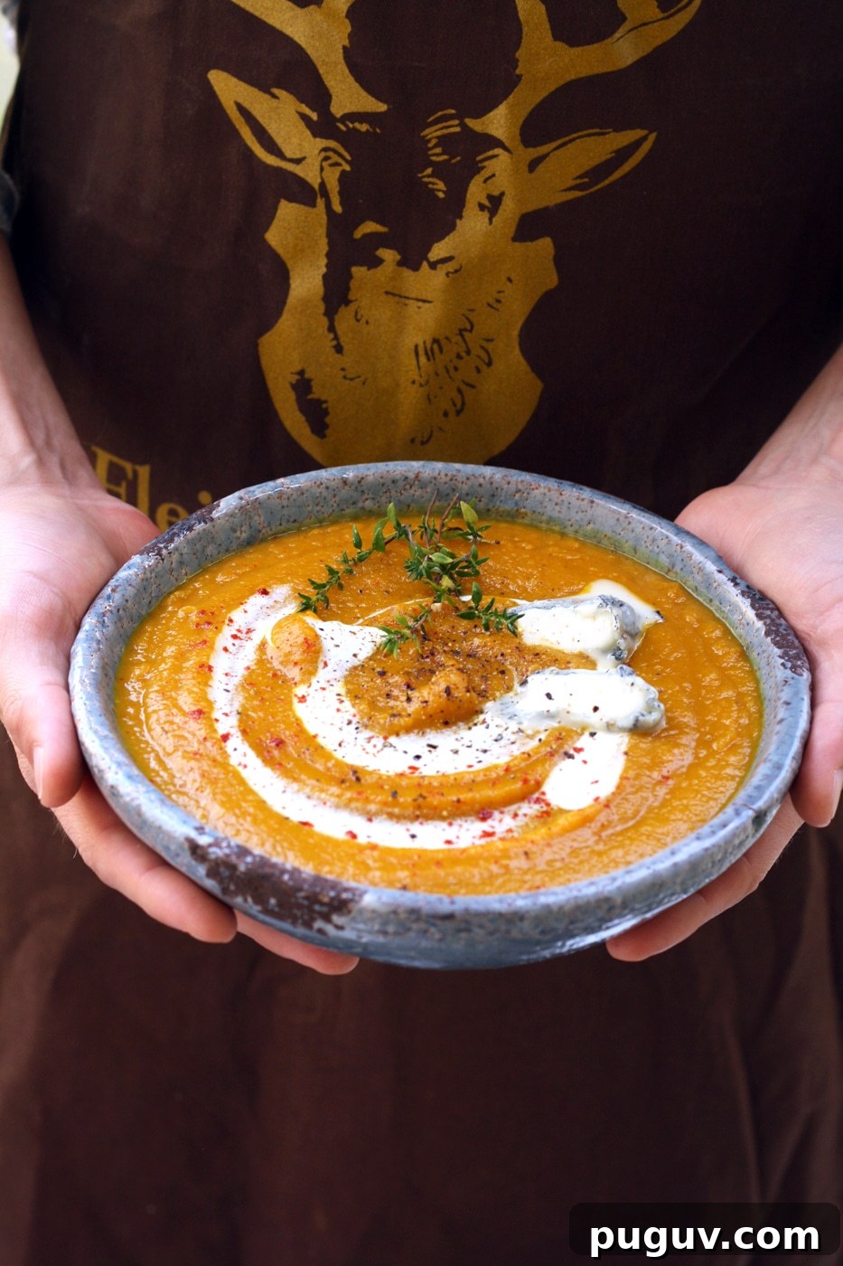 Hands Holding a Bowl of Vegan Butternut Squash Soup.