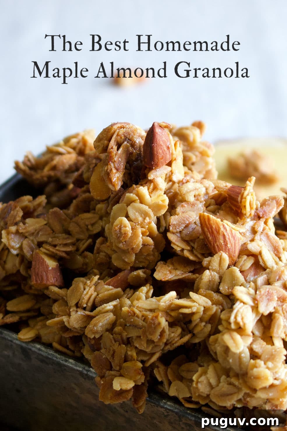 A tin loaf pan filled to overflowing with homemade maple almond granola.