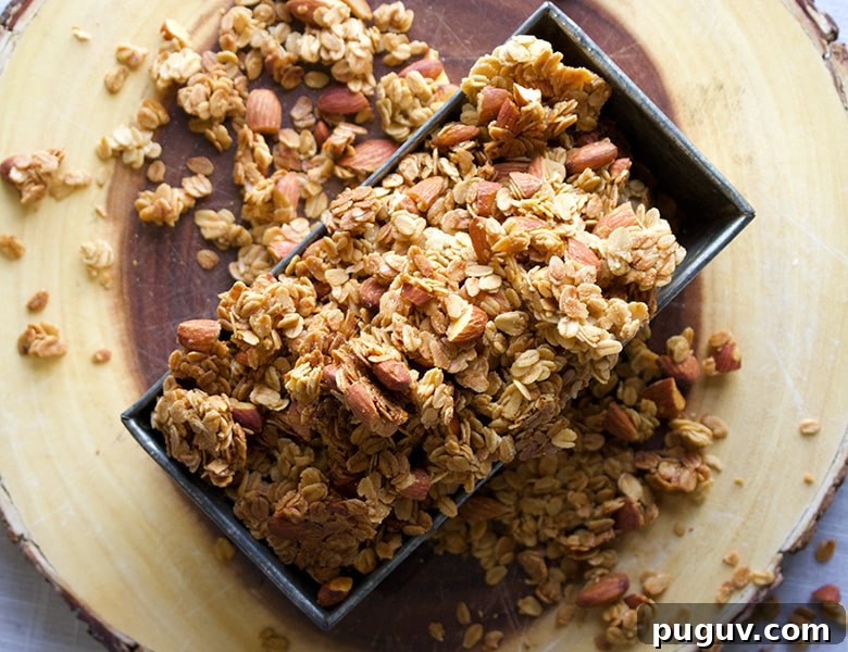 A tin loaf pan filled to overflowing with homemade maple almond granola.