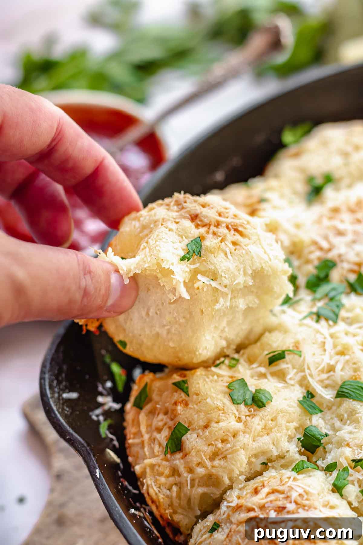 A hand pull a bread bite out of the pan.