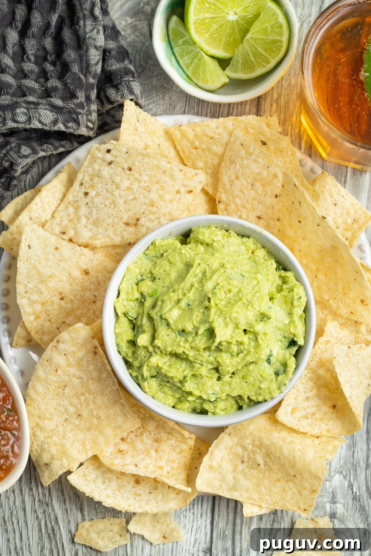 This is a picture of a bowl of guacamole with chips.