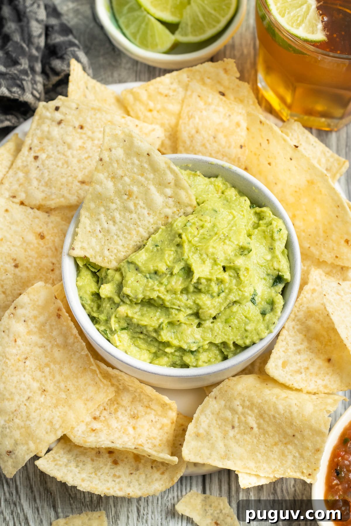 This is a picture of a bowl of guacamole with chips.